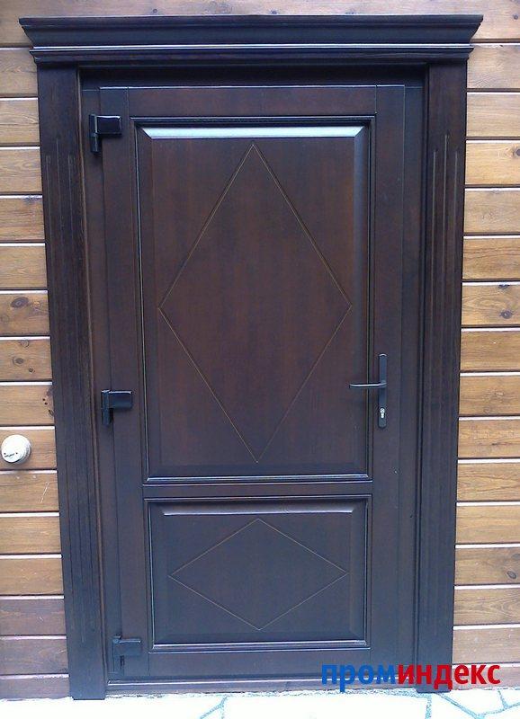 Фото Входная деревянная дверь с карнизом и наличниками